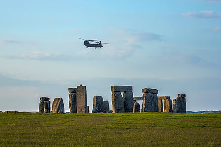 chopper flying above Stonehenge during daytime thumbnail