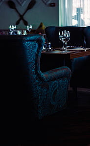 blue and brown paisley print sofa in front of wooden table with two clear wine glasses inside room thumbnail