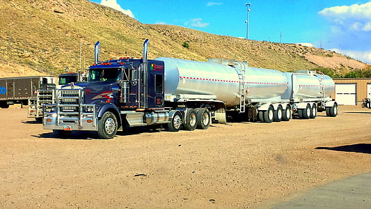 Peterbilt truck parked near hill in distant of tower thumbnail