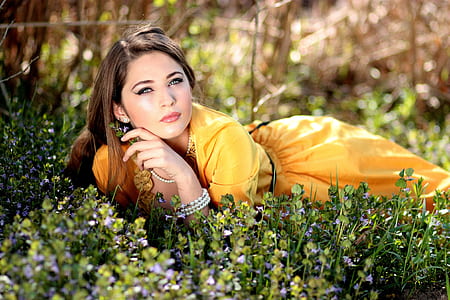 woman wearing yellow dress laying on green grasses thumbnail