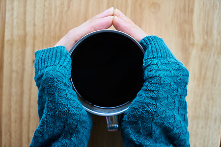 person touching black mug thumbnail