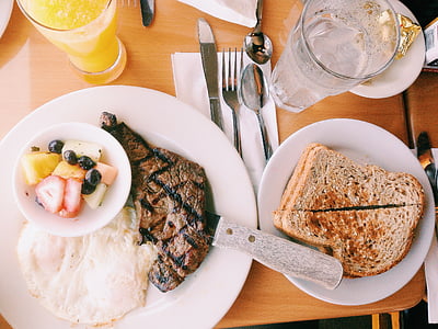 roasted meat and bread dishes on white ceramic plates thumbnail