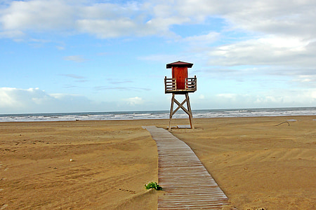 brown and white beach guardhouse on seashore at daytime thumbnail