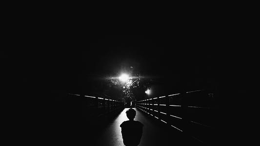 silhouette of person walking on bridge at night time thumbnail