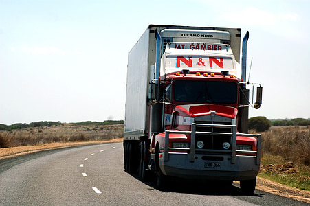 red and white freight truck on gray road thumbnail