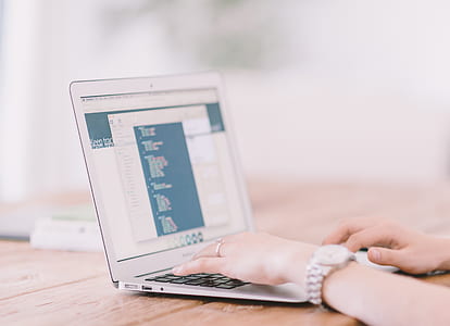 person using MacBook Air on brown wooden table thumbnail