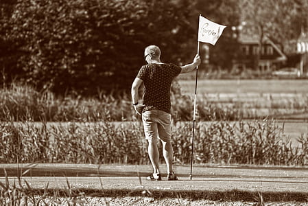 man standing beside flagpole thumbnail