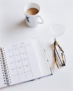 white ceramic mug beside monthly planner notebook thumbnail