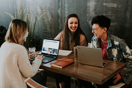 two women and man leaning on table thumbnail