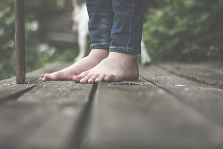 selective focus photography of person standing on wooden pathway thumbnail