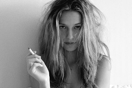 grayscale photo of girl holding cigarette stick thumbnail