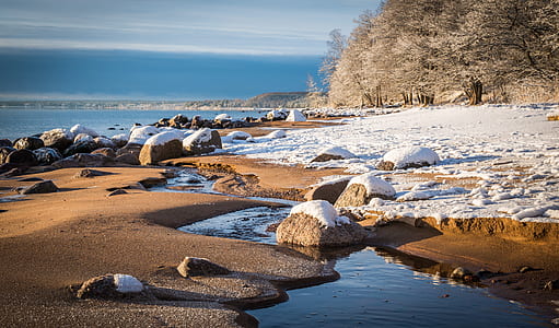 snow on rocks at beach side thumbnail