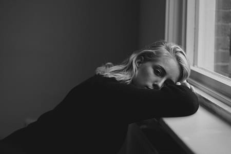woman leaning near window thumbnail