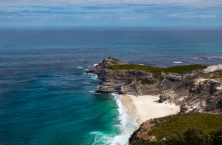 aerial photo of body of water and cliff under blue sky during daytime thumbnail