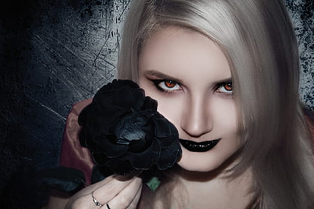 gray haired woman holding black rose flower with black lipstick thumbnail