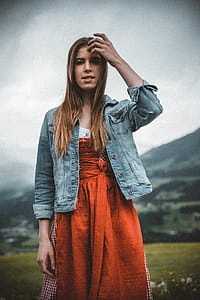 Woman in Blue Denim Button-up Jacket Behind Green Grass Field thumbnail