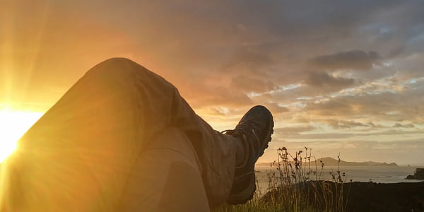 Sun Reflecting on Person Cross Leg Under Cumulus Clouds during Sunrise thumbnail