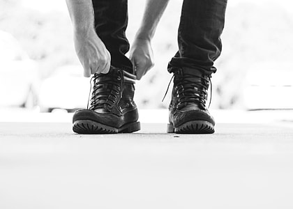 gray scale photo of person wearing jeans and boots thumbnail