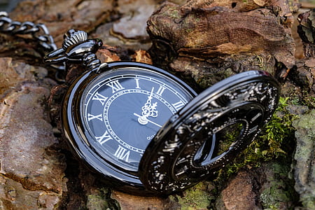 round black pocket watch pointing at 2:08 time thumbnail