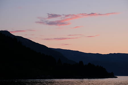 silhouette of mountain beside body of water thumbnail