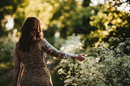 woman standing and holding white petaled flowers at daytime thumbnail