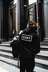 person wearing black jacket standing near building thumbnail