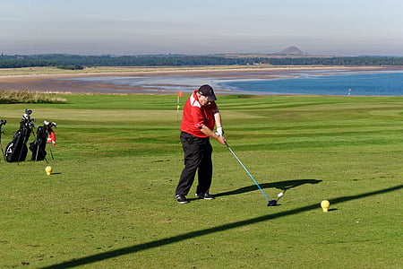 man playing golf on field thumbnail