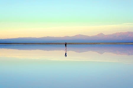 reflection photography of person on body of water thumbnail