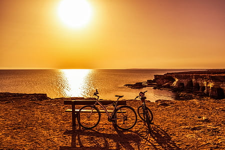 two bicycle beside bench during sunset thumbnail