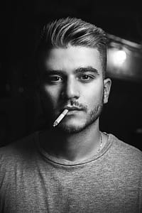 grayscale photo of man with lit ciagarette thumbnail