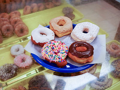 Five donuts sitting on a blue plate. thumbnail