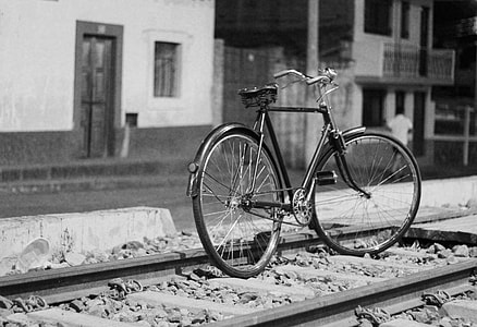 black city bike on train way grayscale photography thumbnail