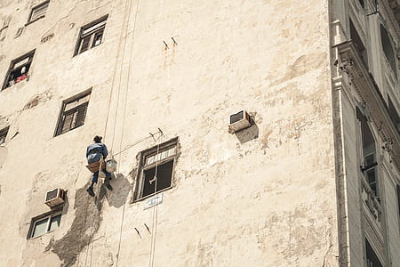 person climbing a brown building thumbnail