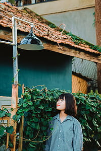 Woman Standing Underneath Pendant Lamp thumbnail