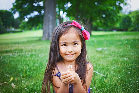 girl holding white flower while smiling thumbnail