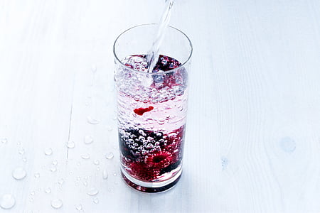 clear drinking glass filled with red, black, and clear liquid thumbnail