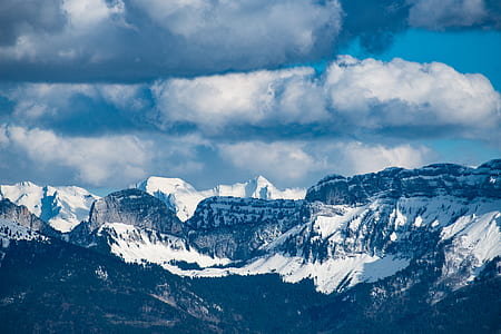 black mountain covered by snow under white skies at daytime thumbnail