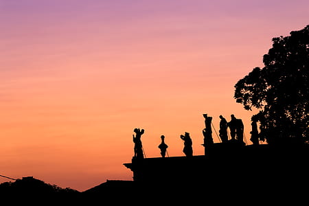silhouette of people standing on cliff thumbnail
