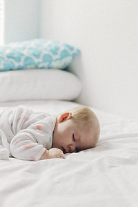 baby wearing white footie pajama thumbnail