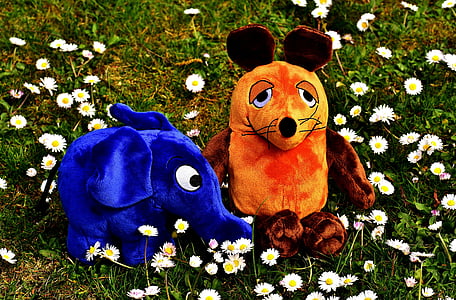 two blue elephant and brown and orange mouse plush toys on white flower field at daytime thumbnail