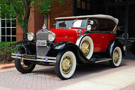classic red car parked beside tree thumbnail