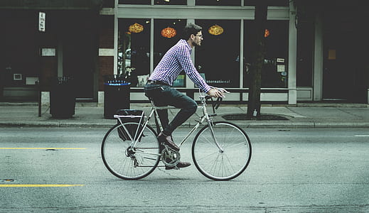 man riding gray road bike thumbnail