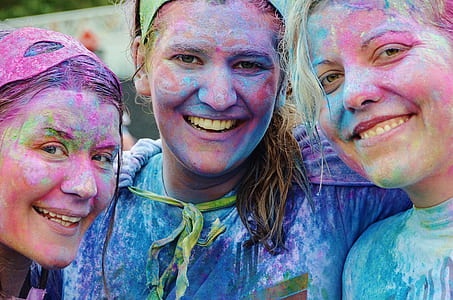 three women with assorted-color on their faces thumbnail