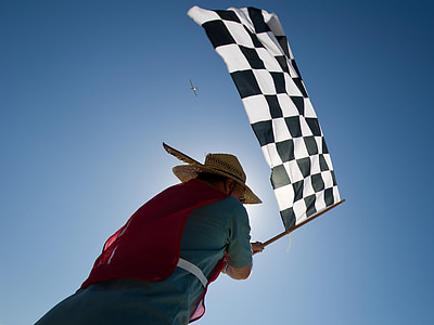 man carrying black and white checkered flag thumbnail