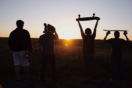 silhouette of four people facing sunset thumbnail