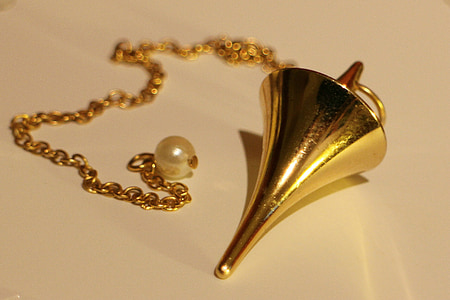 gold-colored pendant necklace on white surface thumbnail