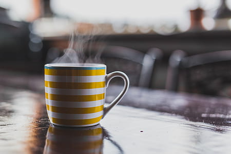 shallow focus photography of yellow and white ceramic coffee mug thumbnail