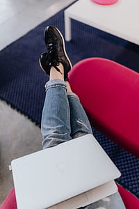 Woman using laptop computer and sitting cross legs on sofa thumbnail