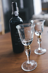 Two empty wine glasses with a bottle of wine on a table thumbnail
