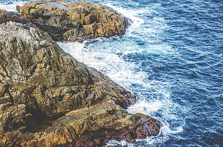 aerial view of green and gray mountain near body of water thumbnail